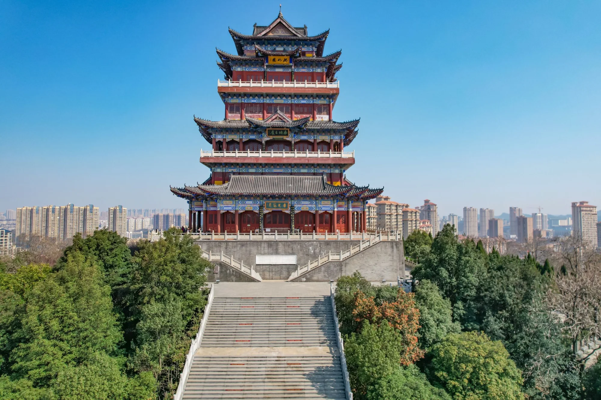 Stunning view of Prince Teng Pavilion with a vibrant cityscape backdrop in Jiujiang, Jiangxi, China.