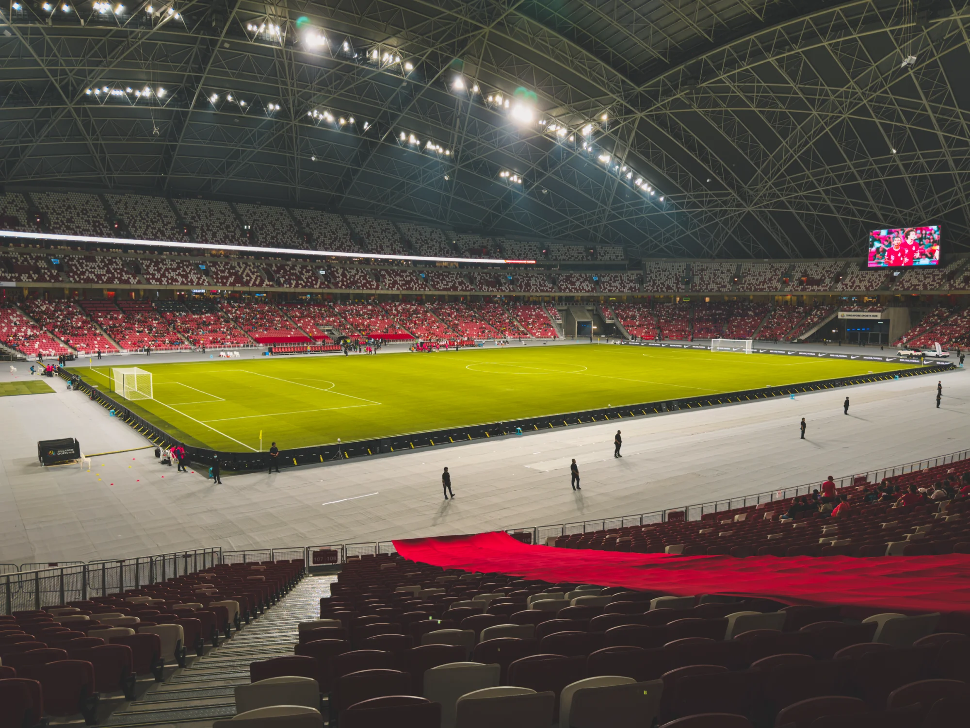Spacious indoor soccer stadium with green field and illuminated seating area.