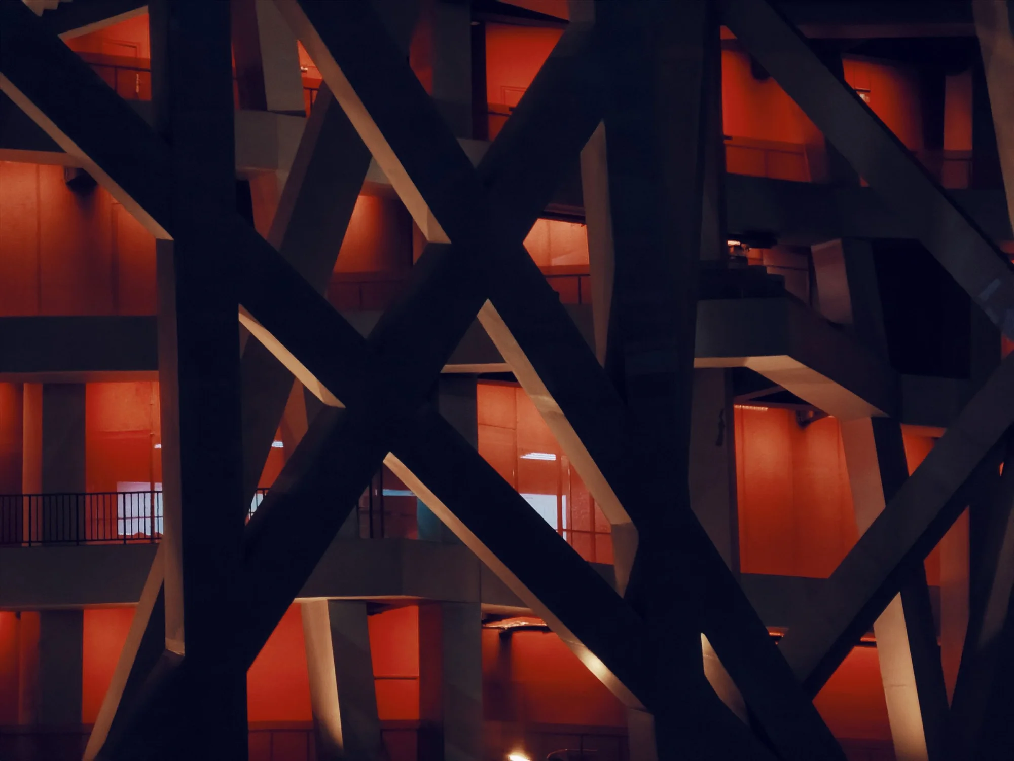 Close-up night view of the National Stadium in Beijing with unique architecture and red illumination.