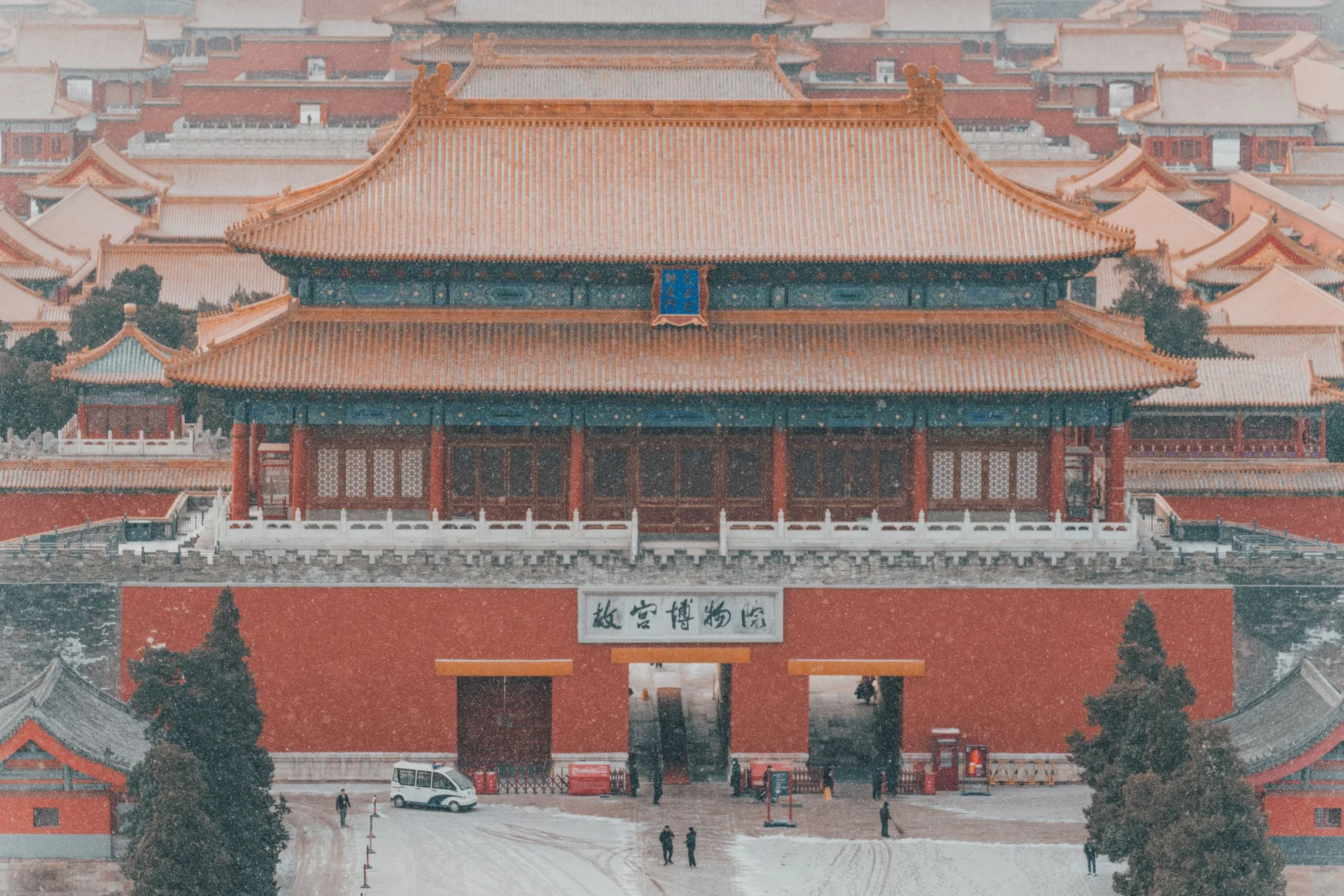 Aerial shot of the Forbidden City covered in snow, highlighting the ancient architecture in Beijing, China.