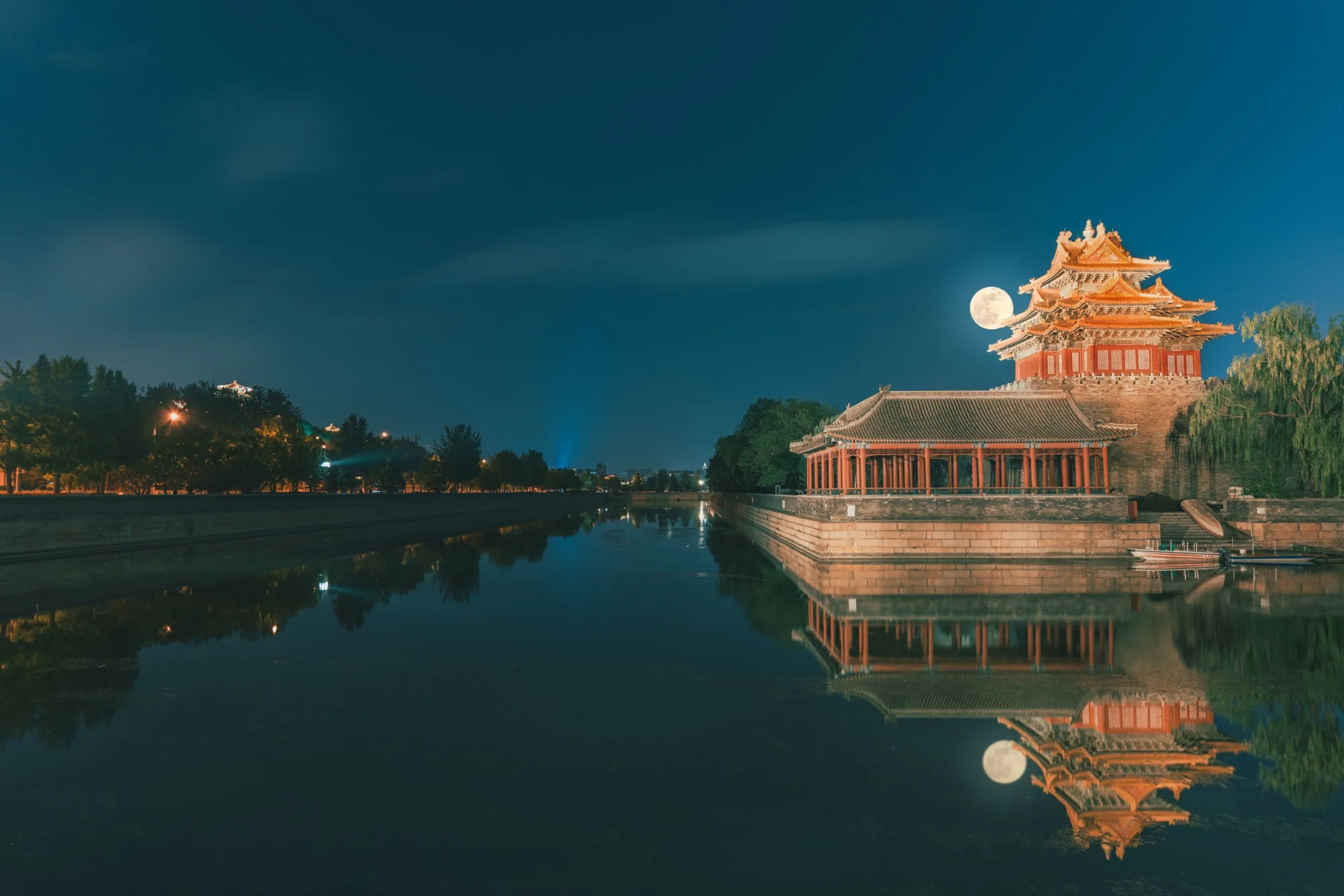 Stunning night view of the Forbidden City reflecting in a pond under a full moon in Beijing.
