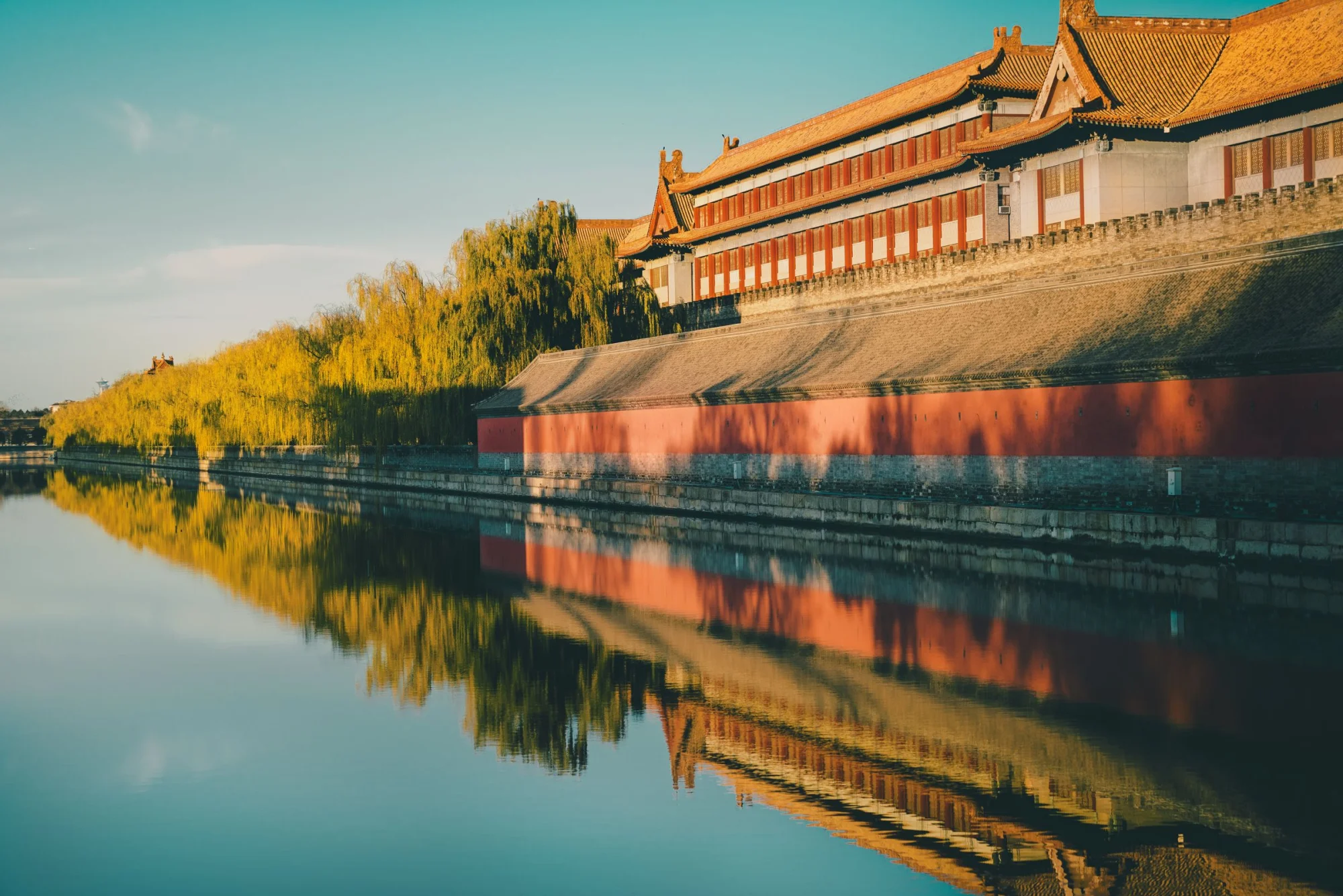 Golden sunset reflects on the historic Forbidden City walls in Beijing, China.