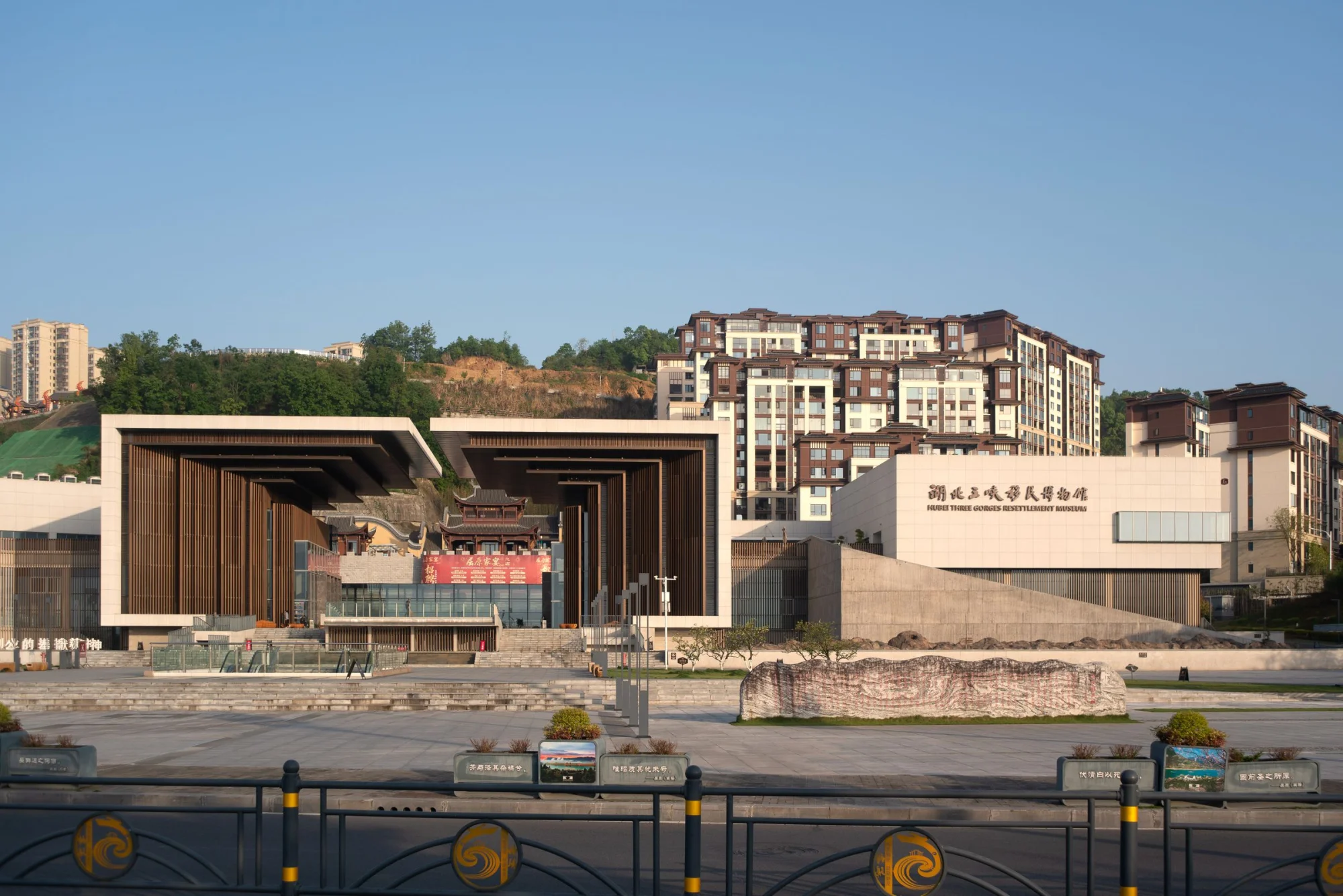 A contemporary view of the Hubei Three Gorges Settlement Museum, showcasing modern design with a city backdrop.