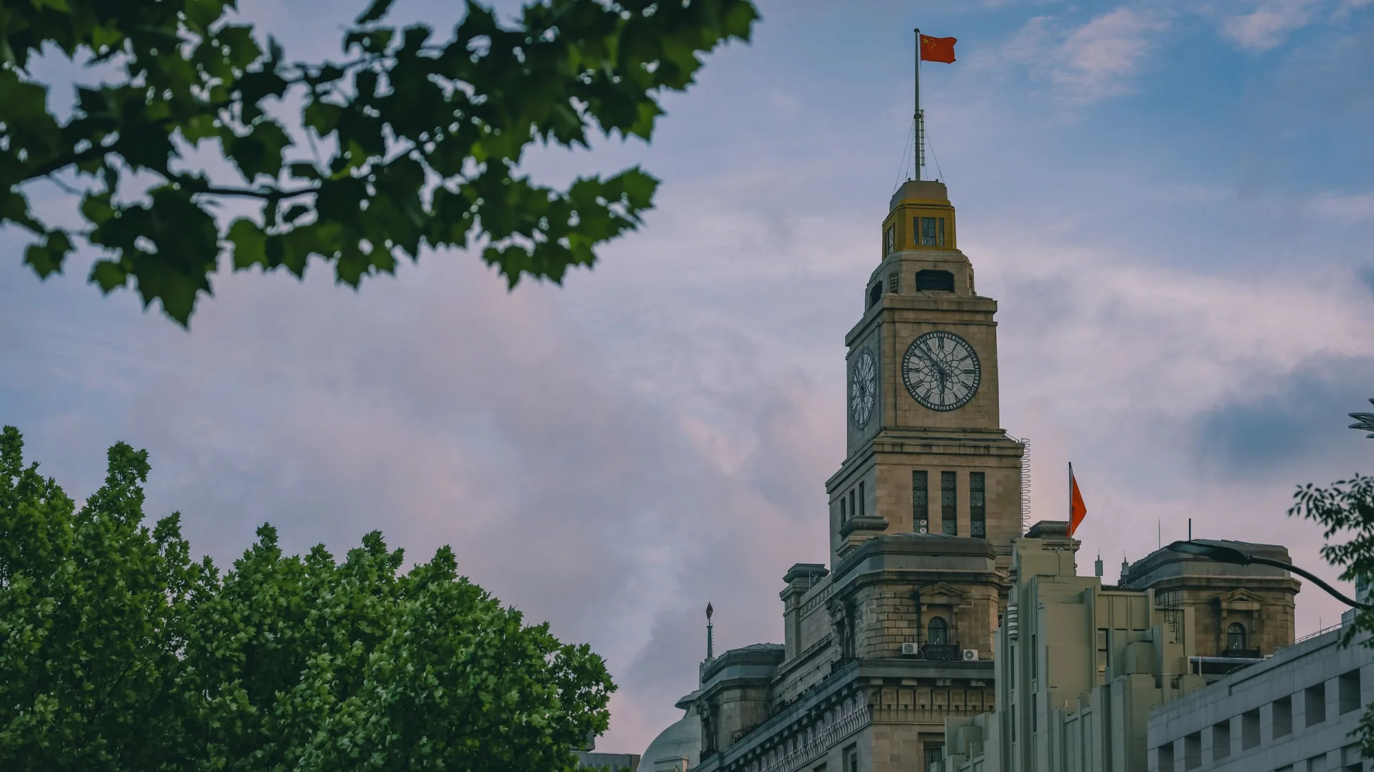 A vintage clock tower in Shanghai, China with an iconic design and evening sky backdrop.