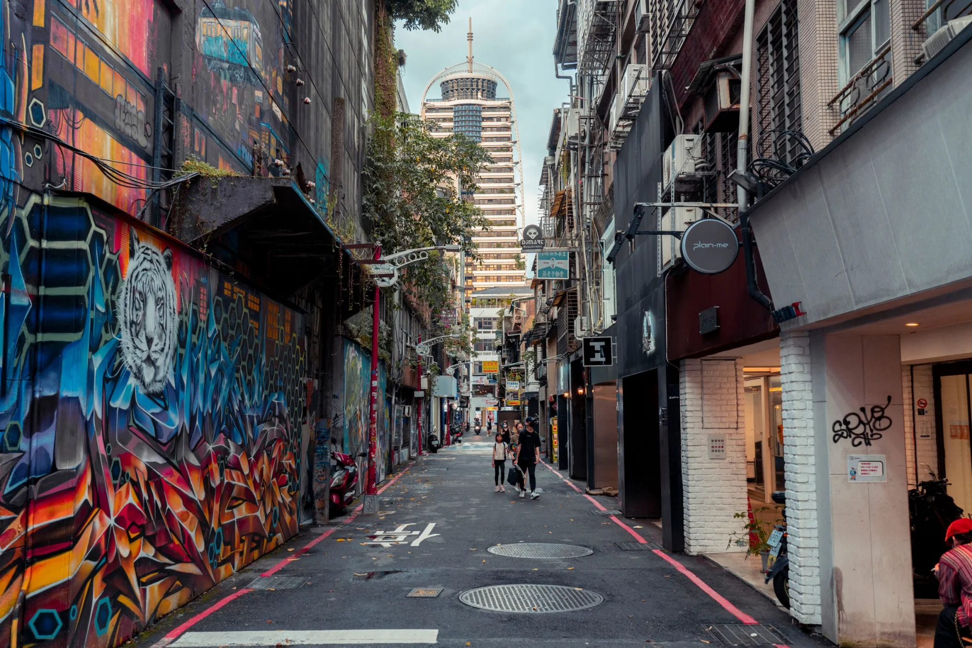 Vibrant urban street featuring colorful graffiti and walking pedestrians, capturing the lively city atmosphere.