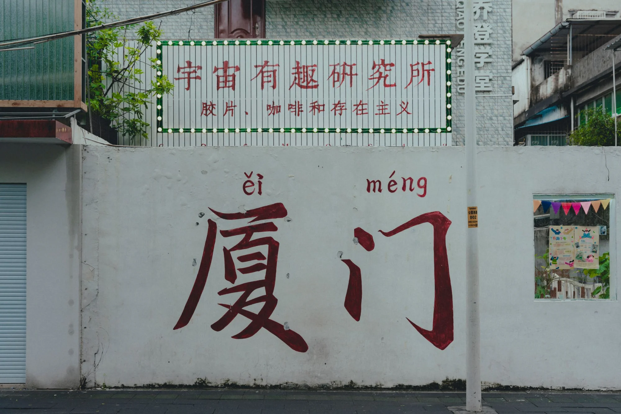 Urban scene featuring a wall with Chinese graffiti and colorful signage.