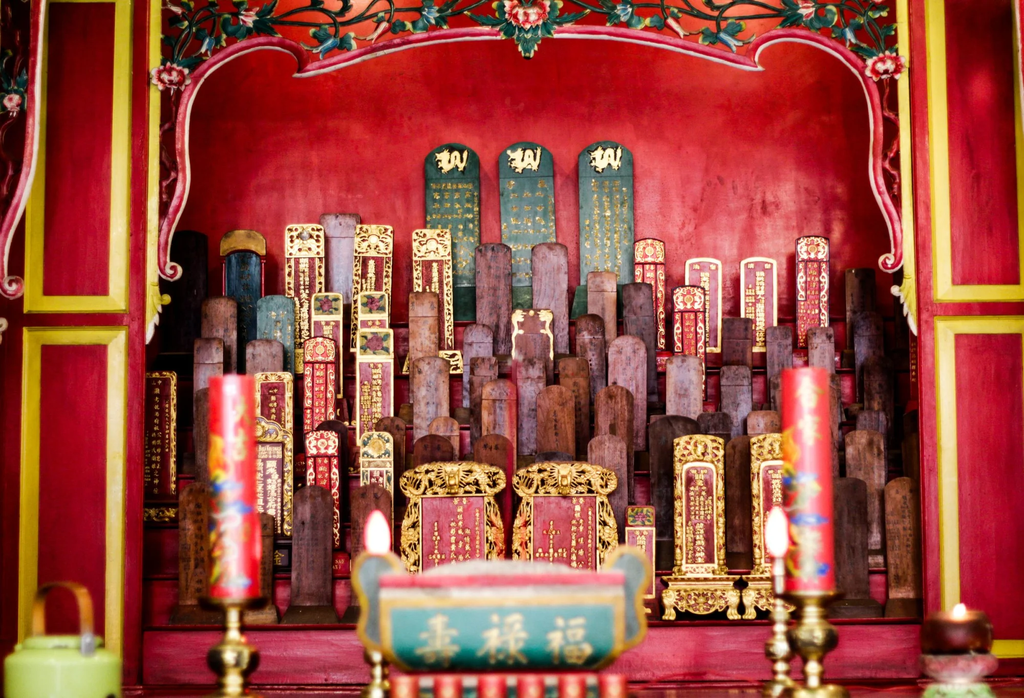 Colorful ancestral tablets and offerings in a traditional temple in Makassar, Indonesia.