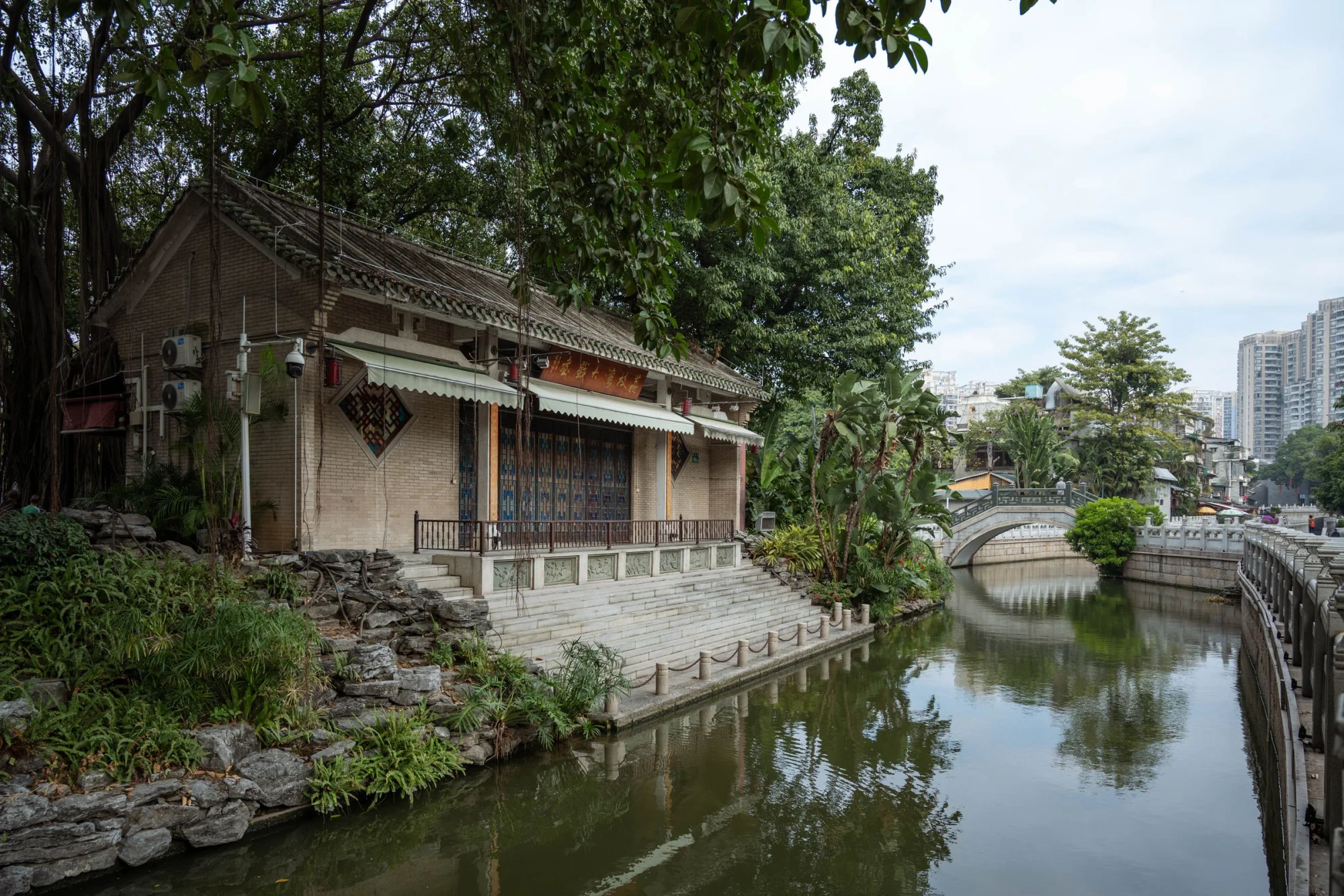 Scenic view of historic architecture and serene river in Guangzhou, China.
