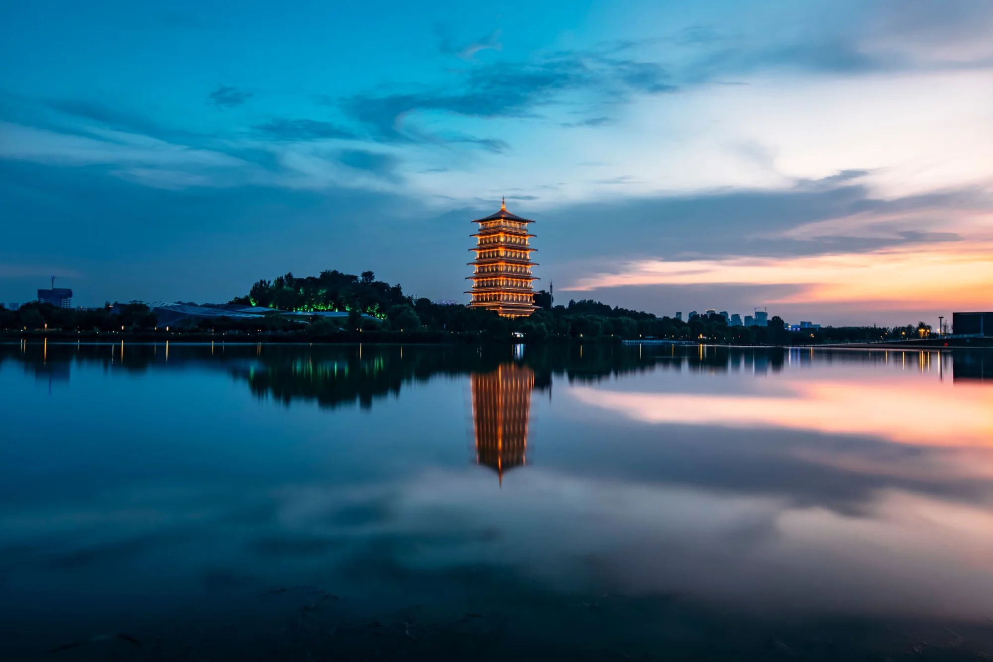 Beautiful sunset reflecting a pagoda on a calm lake, capturing serene tranquility.