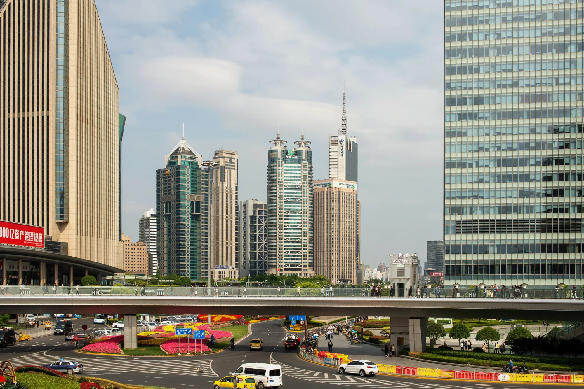 Panoramic view of Shanghai's Lujiazui skyline featuring modern skyscrapers, overpass, and vibrant city life.