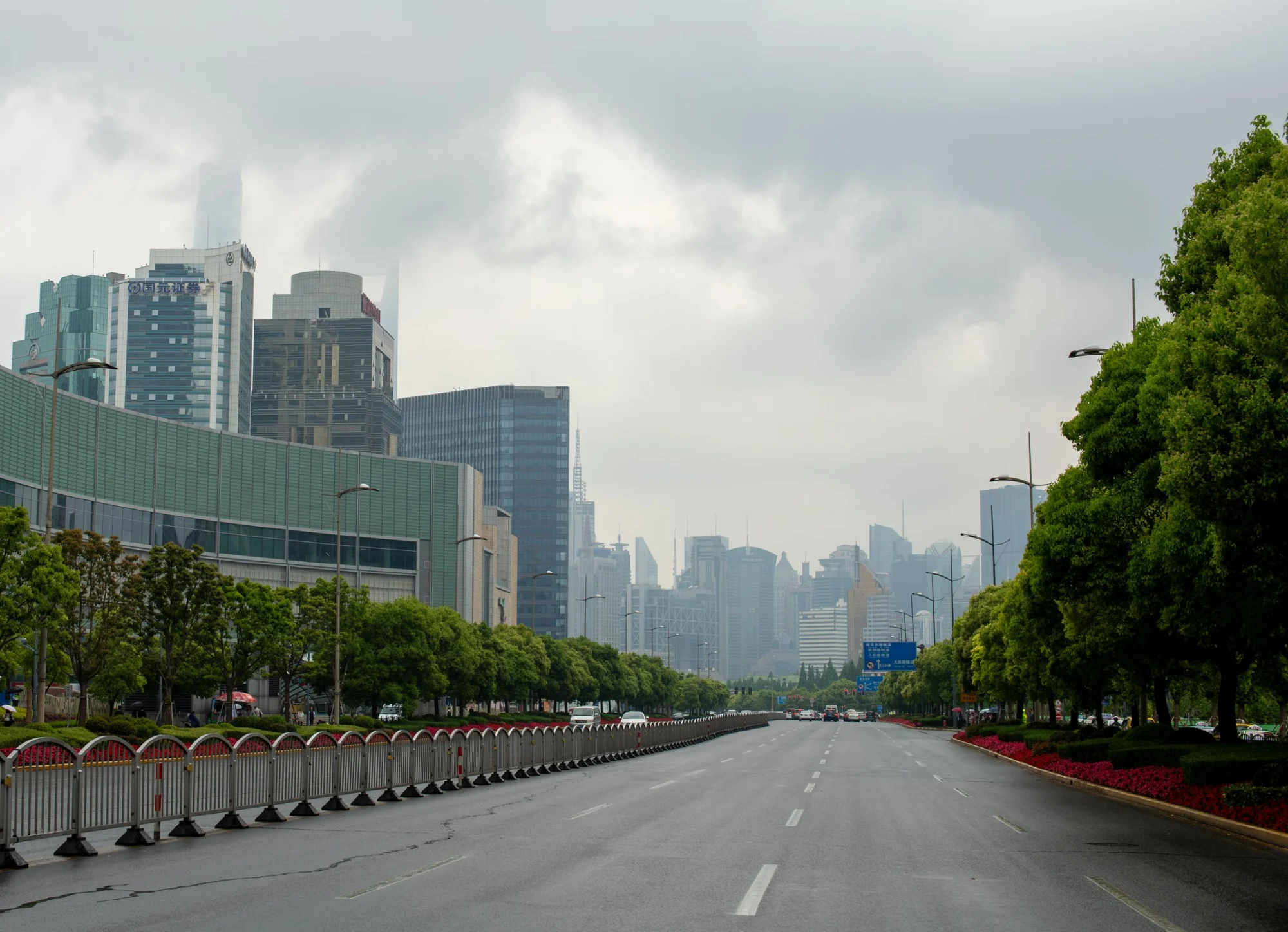 View of Lujiazui area in Shanghai with towering skyscrapers and wide boulevard.