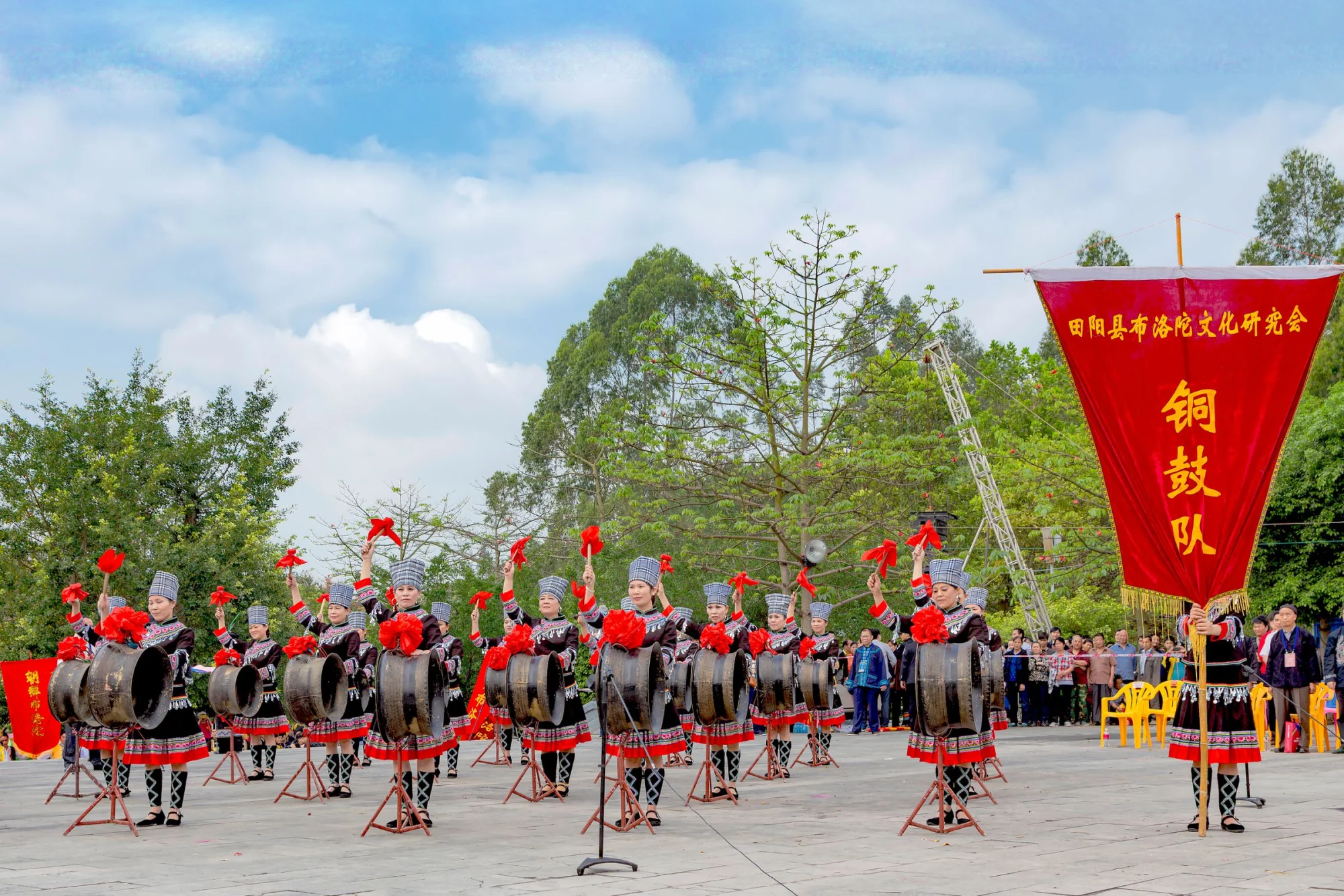 Cultural drum performance outdoors in Guangxi, China, showcasing traditional attire.
