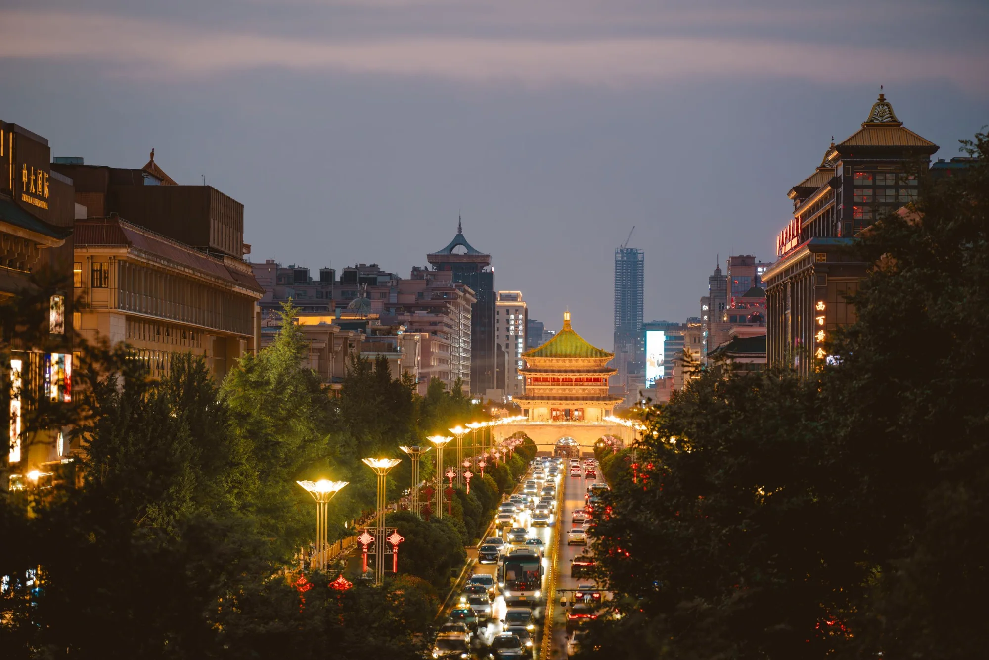 Scenic evening view of Xi'an Bell Tower with lively streets and illuminated architecture.