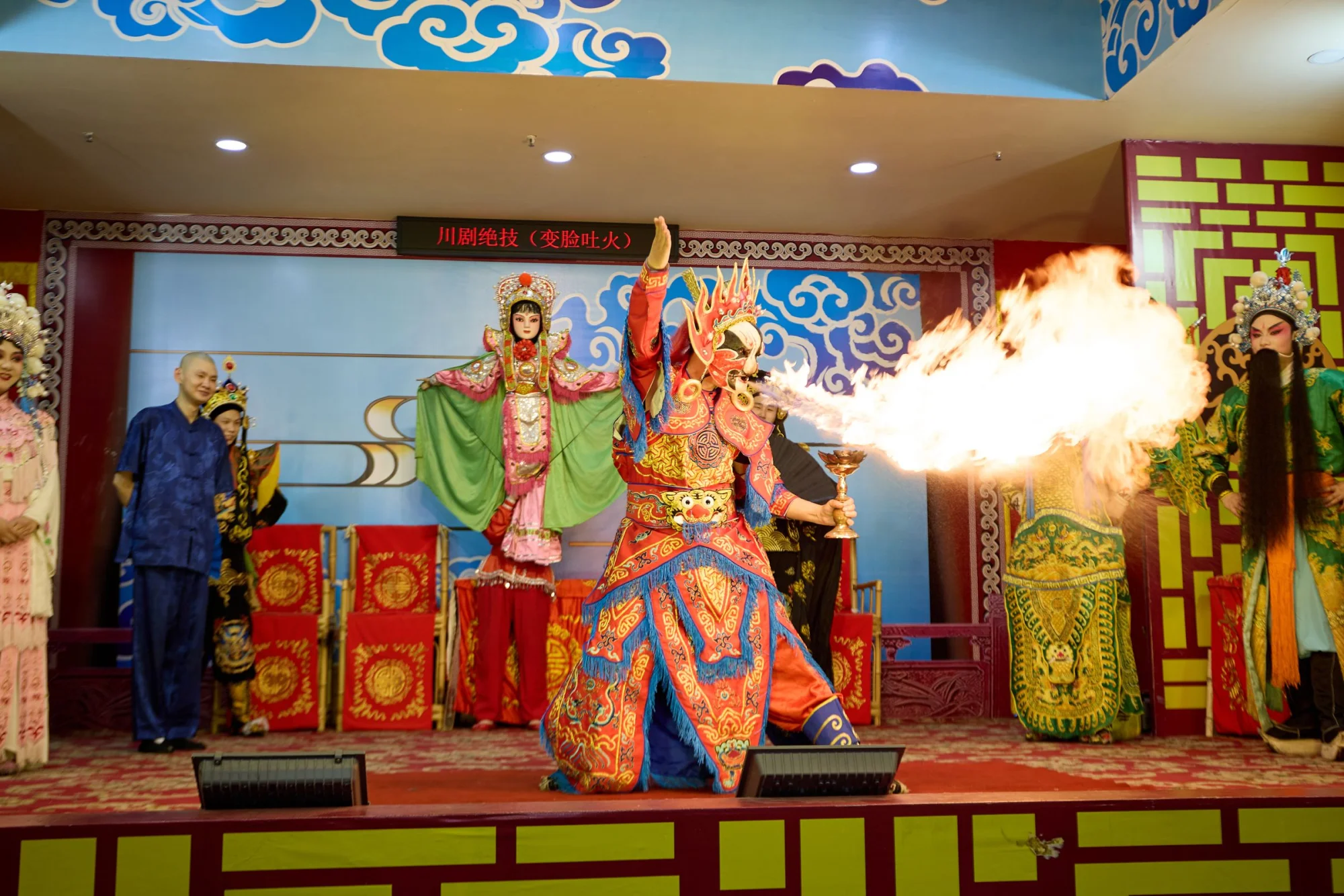 Dramatic Sichuan Opera stage performance featuring colorful costumes and fire-breathing act.