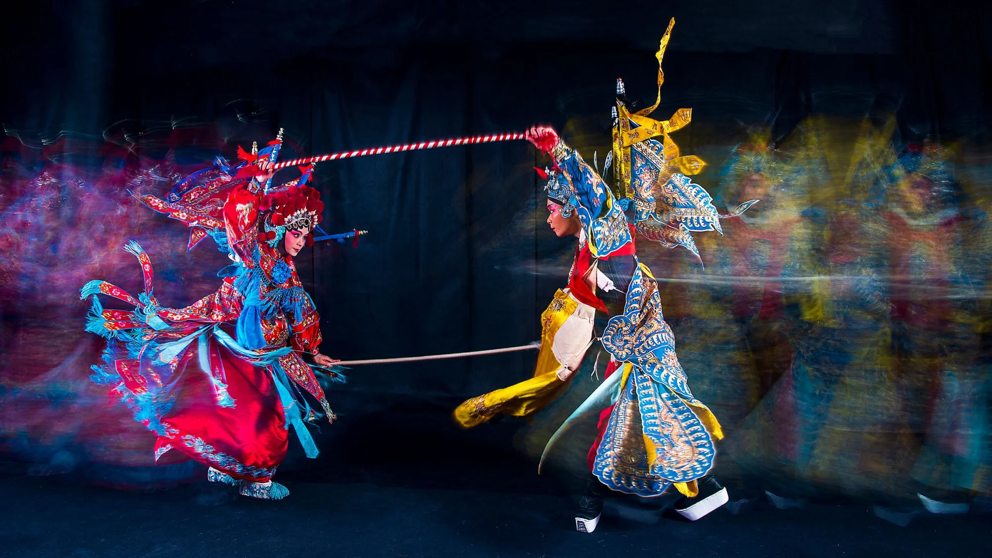 Vibrant capture of a Chinese opera performance with performers in traditional attire, showcasing vivid costumes and motion blur.