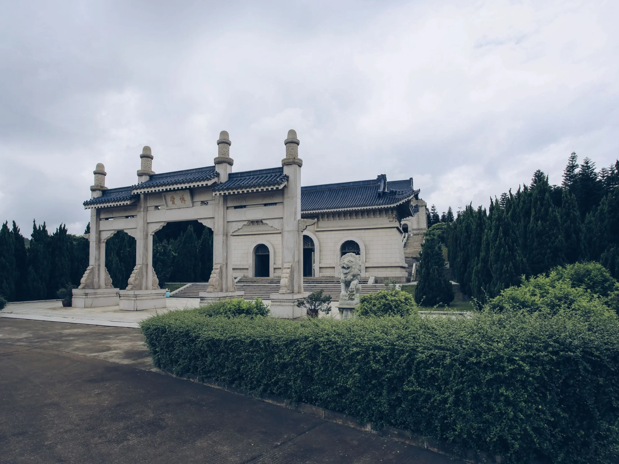 View of the grand entrance of Dr. Sun Yat-sen's Mausoleum surrounded by lush greenery.