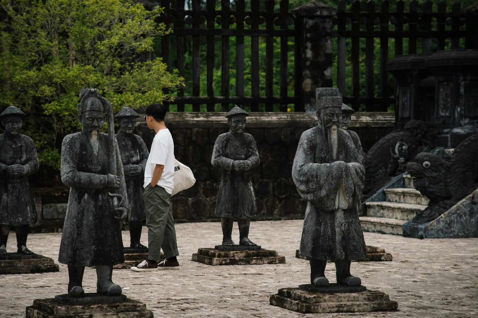 Tourist walking among sculptures at Khai Dinh Mausoleum in Vietnam, a UNESCO World Heritage Site.