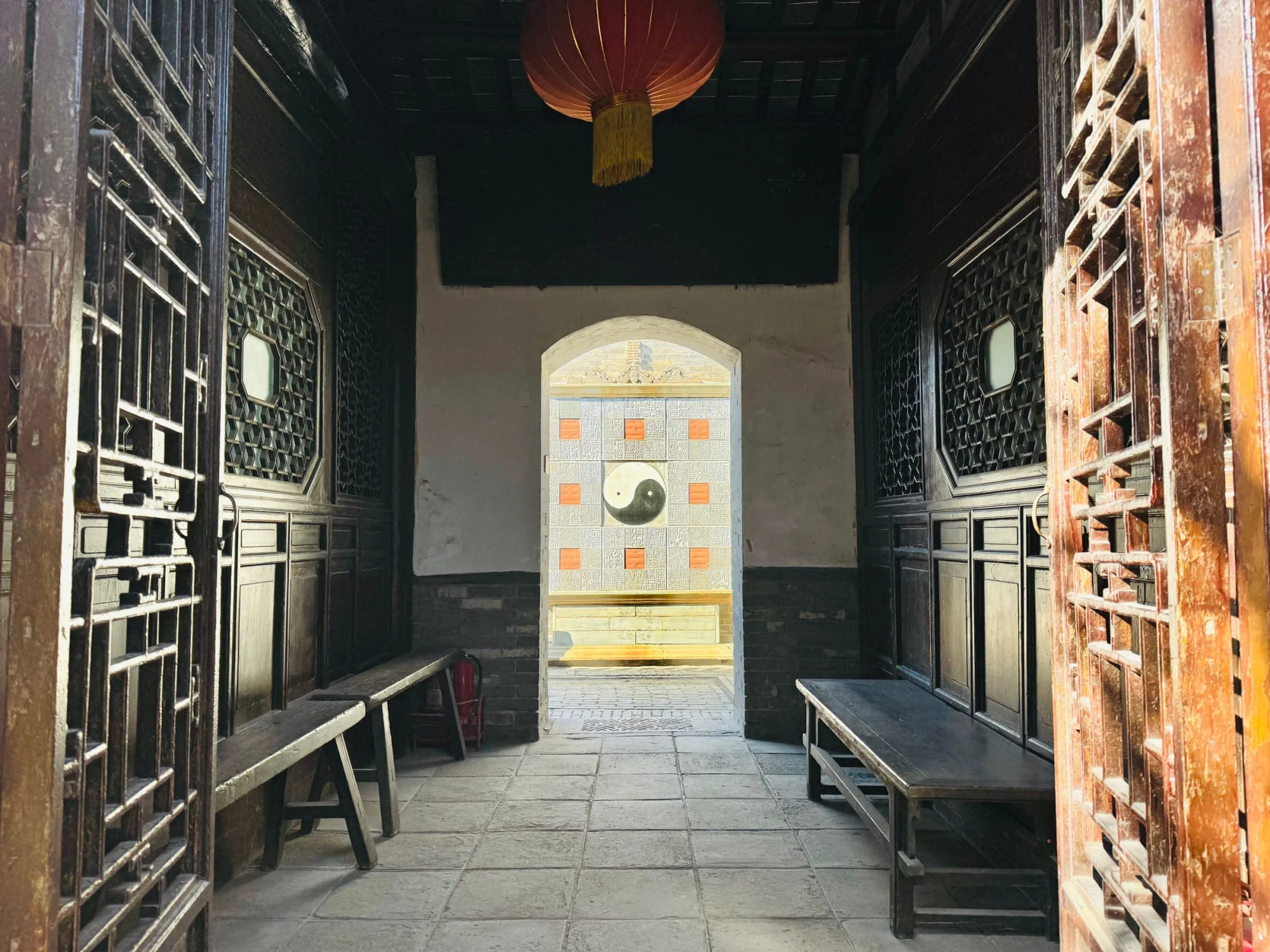 Entrance view of a traditional Chinese courtyard featuring a prominent Yin Yang symbol.